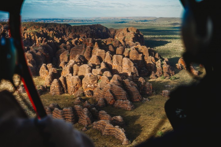 Aerial view of layered, eroded rock formations resembling beehives in a desert landscape.