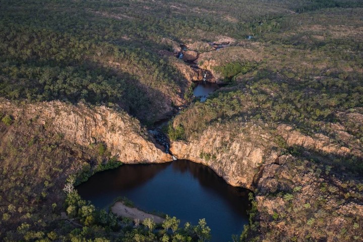 Aerial view of a river flowing between rocky cliffs in a forested landscape.